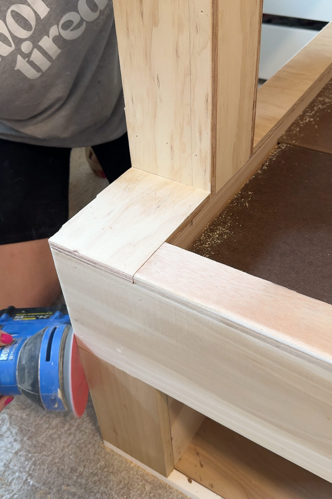 Sanding a built-in DIY kid's bunk bed.